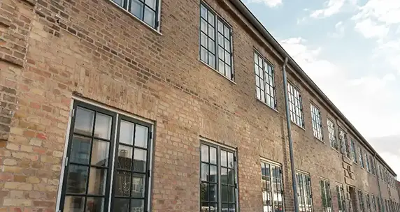 Nyrenoveret murstensbygning med gennemgåede og monterede vinduer af Energitømreren